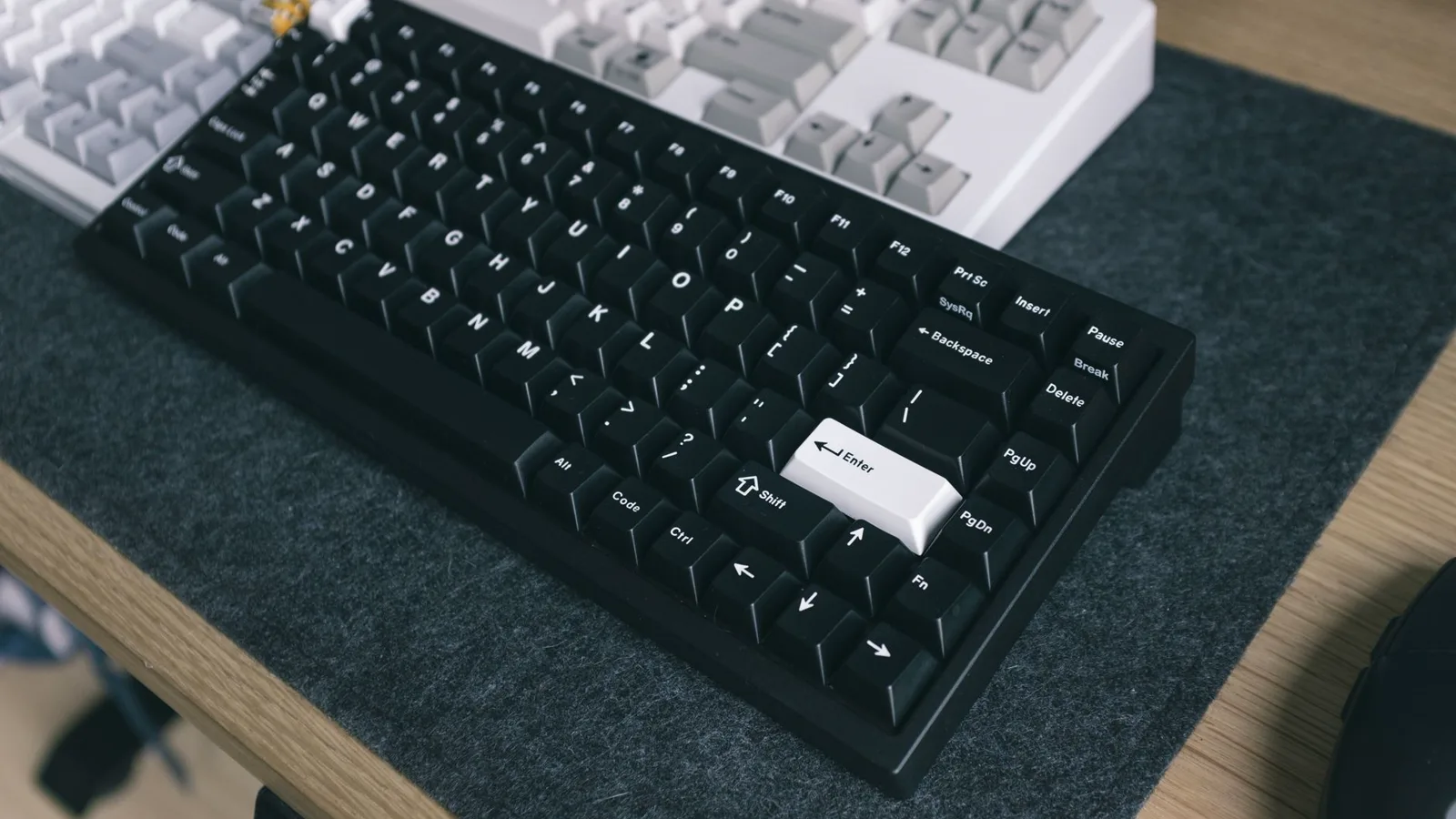 Teclado de membrana desgastado com letras apagadas ao lado de um teclado mecânico colorido e íntegro em mesa de escritório em casa, com calendário marcado ao fundo mostrando passagem de tempo.